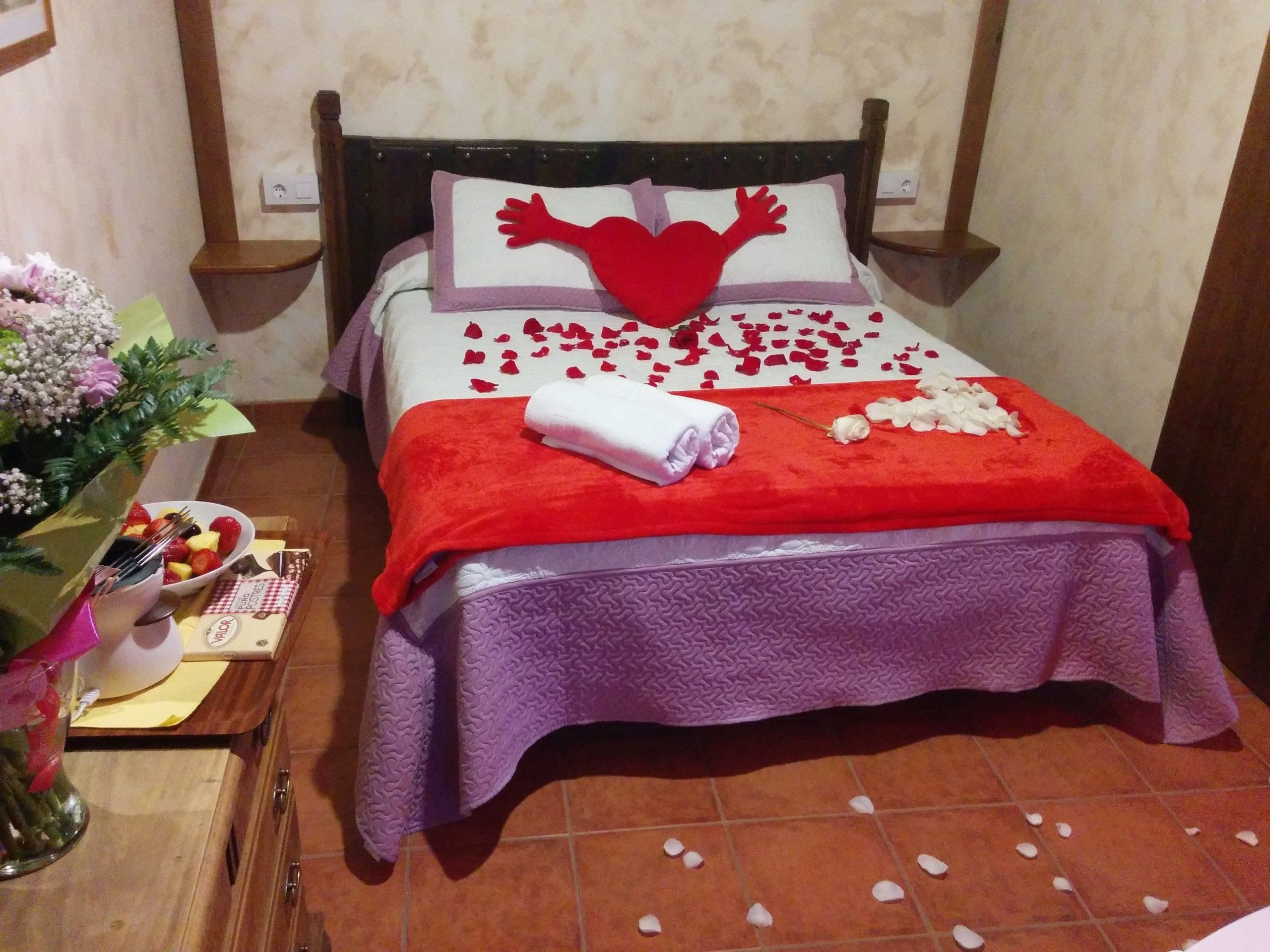 Casa Rural El Berrueco: cama decorada con corazones y pétalos