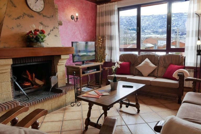 Casa Rural Los Moros: salón con chimenea y sillones